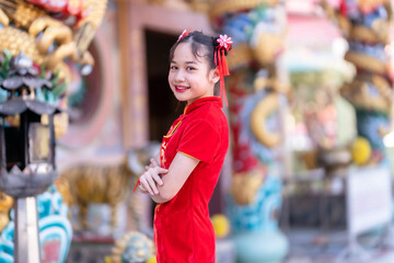 little Cute Asian girl wearing traditional Chinese cheongsam red with paper lanterns with the Chinese alphabet Blessings written on it Is a Fortune blessing compliment decoration for Chinese New Year