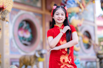 little Cute Asian girl wearing traditional Chinese cheongsam red with paper lanterns with the...