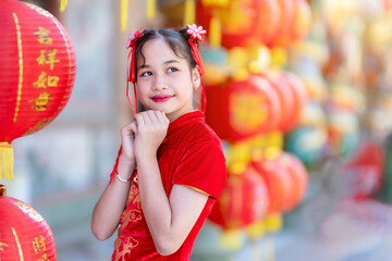 little Cute Asian girl wearing traditional Chinese cheongsam red with paper lanterns with the...