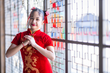 little Cute Asian girl wearing traditional Chinese cheongsam red with paper lanterns with the...