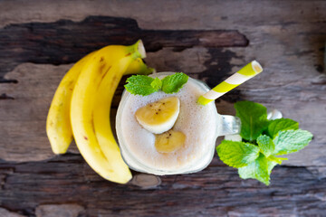 Banana fresh cocktail vanilla smoothies  fruit juice beverage healthy the taste yummy in glass drink episode good morning on wooden background from the top view.