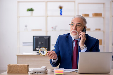 Old male employee working in the office