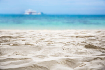 Fototapeta na wymiar Tropical sandy beach with blurry blue ocean and sky.