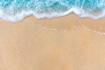 Fototapeta na wymiar Soft beautiful blue ocean wave on sandy beach. Background. top view