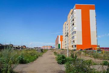 Fototapeta na wymiar Modern apartment buildings. kazakhstan (Ust-Kamenogorsk). New residential area. Contemporary architecture. Blue Sky and Green Grass. New Houses