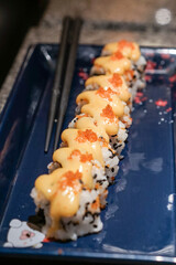 Spicy Creamy Sushi roll with red caviar. Roll with soft spicy creamy cheese under a layer of massago caviar. Classic sushi. Food background