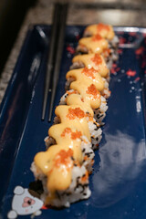 Spicy Creamy Sushi roll with red caviar. Roll with soft spicy creamy cheese under a layer of massago caviar. Classic sushi. Food background