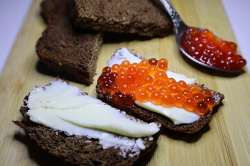 Sandwiches with red caviar on black bread