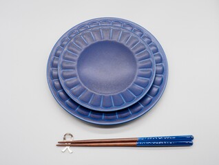 白い背景の上に重ねられた紺色の空いたお皿