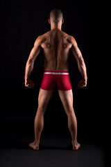 Fototapeta na wymiar Studio photo of the back of strong man, black background