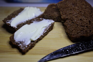 Sandwich with butter. Bread on the board cut into slices
