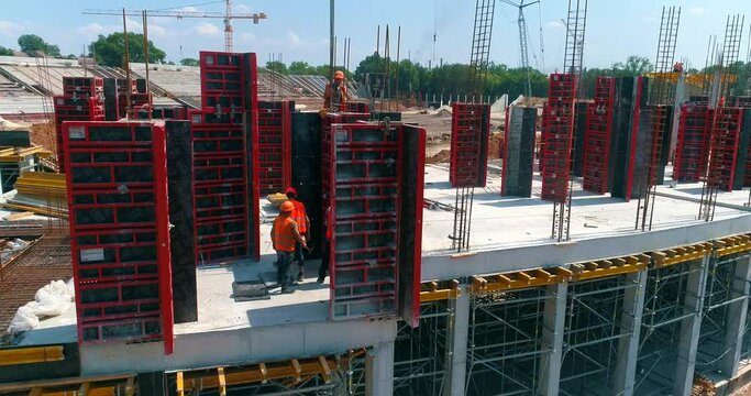 Construction process of a modern football stadium. Builders make formwork at the construction site of a new stadium. Aerial view of reinforced concrete construction