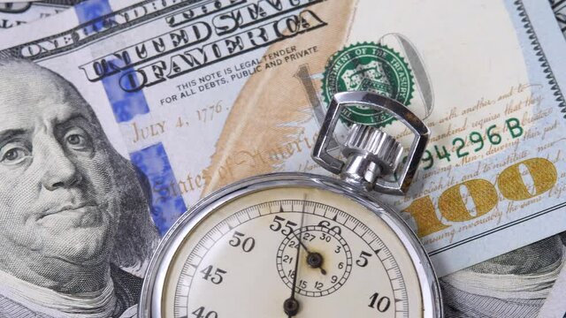 100 USD denomination note with metal stopwatch. Time is money. Currency or cash revenue, business or financial concept