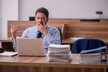 Young male employee and too much work in the office