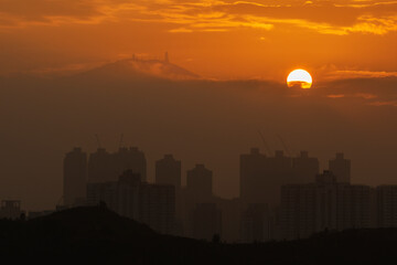 Idyllic sunrise landscape of mountain Tai Mo Shan and city skyline of Hong Kong