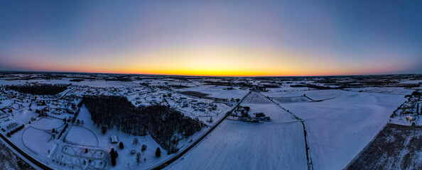 panorama of winter sunset in rural wisconsin farmland