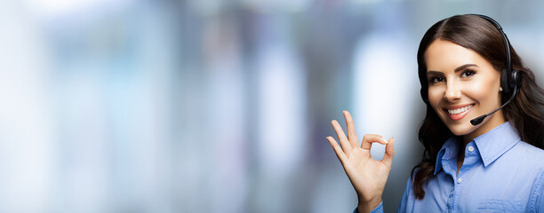 Customer support phone operator in headset showing ok okay or zero hand sign gesture, over blurred...