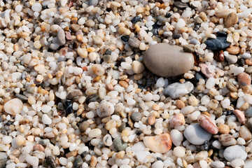 The sand on the beach is fine, natural stone. Concept of sandy stone wallpaper, background and decor, light brown color.