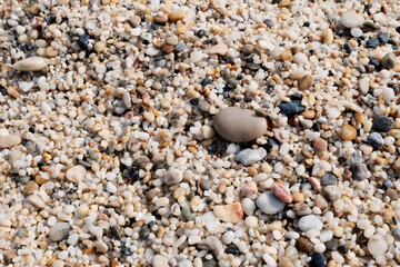 The sand on the beach is fine, natural stone. Concept of sandy stone wallpaper, background and decor, light brown color.