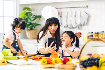 Portrait of enjoy happy love asian family mother and little asian girl daughter child having fun help cooking food healthy eat together with fresh vegetable salad and sandwich ingredient in kitchen