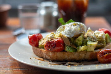 Avocado toast with a poached egg and tomatoы. Healthy Food, breakfast. close up shot 