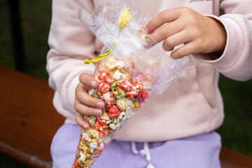 Girl eating colored popcorn in a transparent bag