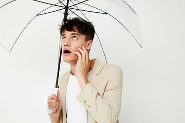 nice young guy with an open umbrella in a suit light background