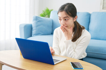 女性　パソコン　驚き　リビング