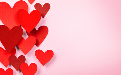 composition for valentine's day from volumetric red hearts on a pink background