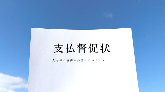支払督促状の文字入りの白い紙_青空背景正面