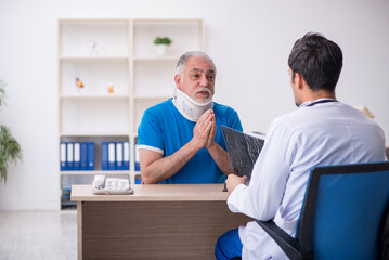 Obraz premium Old male patient visiting young male doctor radiologist
