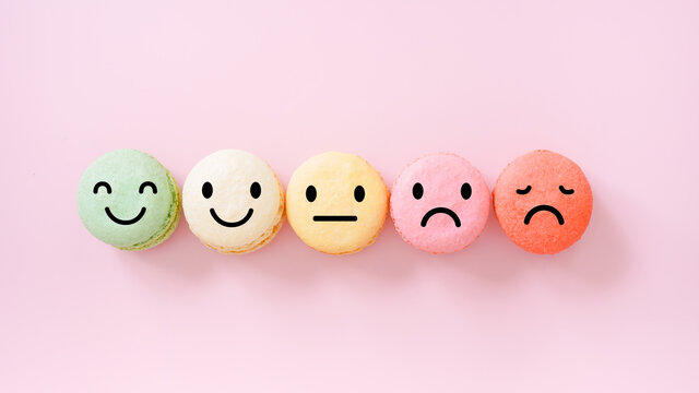 emotion face on multi colored macarons , good feedback rating and positive customer review, experience, satisfaction survey ,mental health assessment, child wellness, world mental health concept