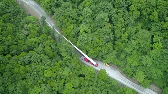 Wind power generator blades are being transported along the road in the forest. 풍력발전기 블레이드 운송.