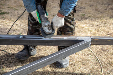 A worker cuts metal at a construction site. Technology