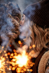 Couple Love Story in Snow Forest Kissing and Holding Sparklers. Couple in Winter Nature. Couple Celebrating. Valentine's day date.