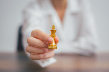 Hand holding golden chess king, King wins the game, success, strategy, victory, win checkmate, Concept leadership and business strategy plan success in business competition.