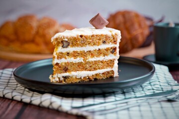 Carrot cake slice with cream cheese frosting.