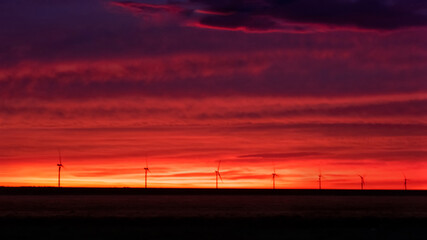 Taken in the Texas panhandle at sunrise.  Windmill electric farm in the distance.