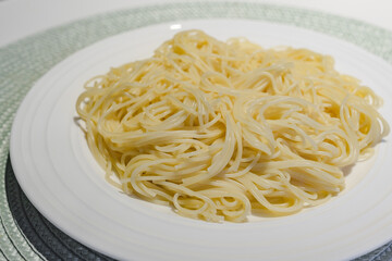 Fresh cooked spaghetti pasta on white plate close up