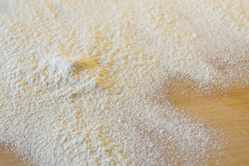 White flour on rustic wooden table, close up view