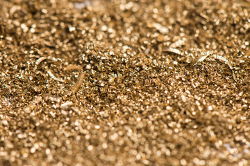 Small shavings of brass after lathe work. Industrial waste from the metallurgical industry. Selective focus. - obrazy, fototapety, plakaty