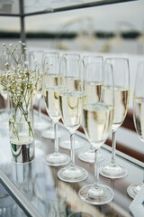 Fototapeta na wymiar Glasses of champagne at the Banquet, white sparkling wine in wine glasses, festive mood