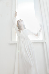 pretty woman in white dress stands near from the sun luxury