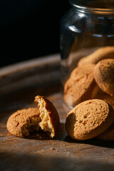 Food photography details. Close up view of some home made cookies next to a glass jar on a wooden table. Perfect for breakfast of with a coffee.