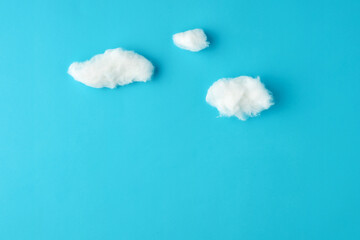 Fluffy clouds made out of cotton on pastel blue sky background. Creative meteorology weather or...