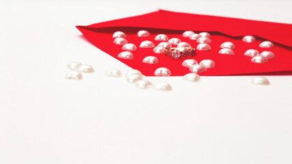 Marry me concept, wedding engagement ring with with red paper envelope and hearts on white background. Happy valentines day present. Close up, copy space.