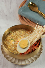 Korean traditional Ramyeon noodle with egg yolk, chilli, kimchi in a traditional korean noodle pot