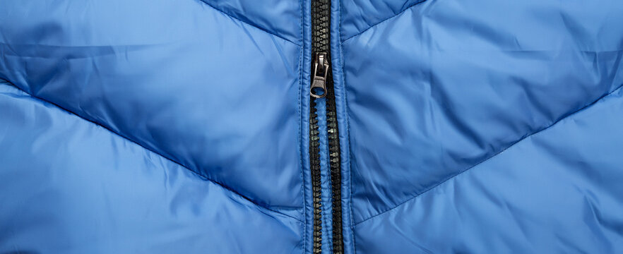 Close-up On Blue Puffer Jacket Texture With Zipper. Fabric Background