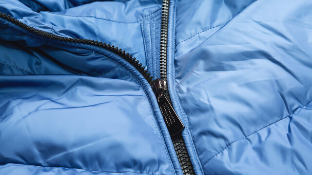 Close-up On Blue Puffer Jacket Texture With Zipper. Fabric Background