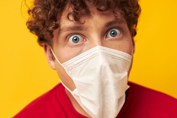 Young curly-haired man in protective masks safety posing isolated background unaltered